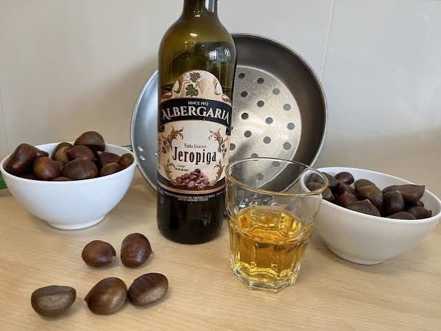 Botella de jeropiga junto a castañas asadas